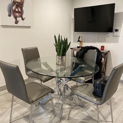 Used kitchen table set, glass top, silver leather chairs for sale on AptDeco