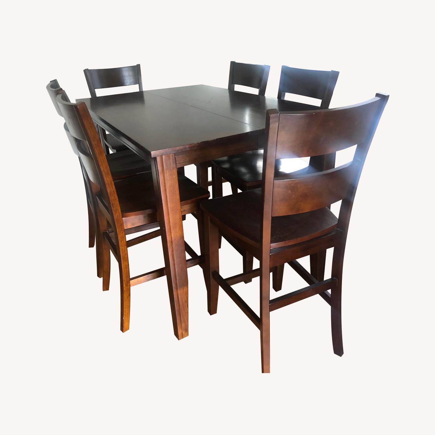 Dark brown dining table w/ 6 chairs & an extension piece. - image-0