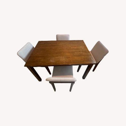 Used Wooden Table W Four Cushion Chairs for sale on AptDeco