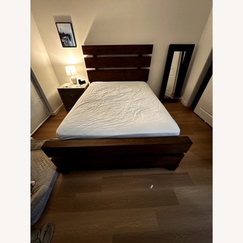 Used Raymour & Flanigan Dark Brown Wood Queen Bed for sale on AptDeco