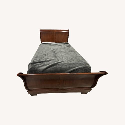 Used Raymour & Flanigan Dark Brown Wood Queen Bed for sale on AptDeco