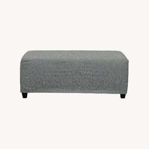 Used Slip Covered Ottoman on Wood Feet	 for sale on AptDeco