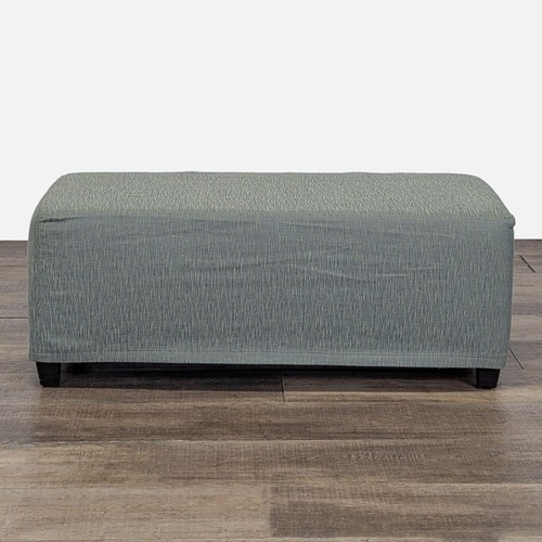 Used Slip Covered Ottoman on Wood Feet	 for sale on AptDeco