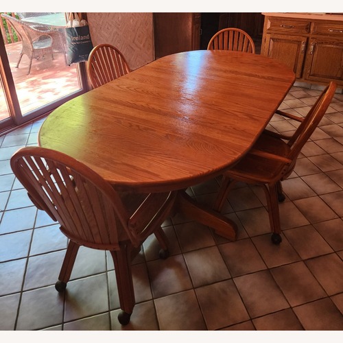 Used Solid Oak Dining Table with 4 Rolling Chairs for sale on AptDeco