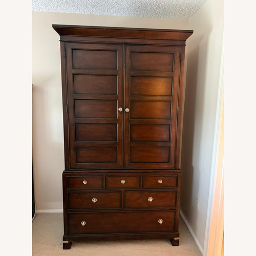 Used Macy's Dark Tea Trade Brown Wood Armoire for sale on AptDeco