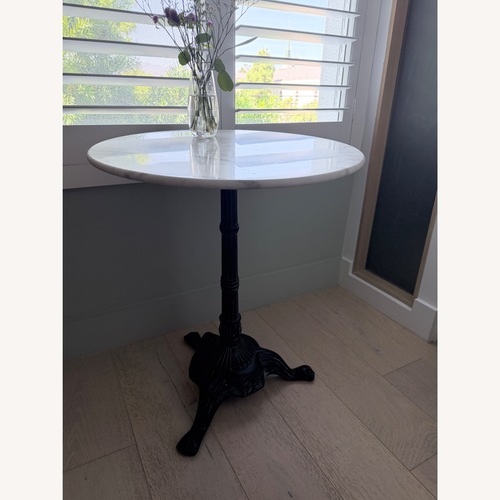 Used World Market Round White Marble and Black Metal Bistro Side Table for sale on AptDeco