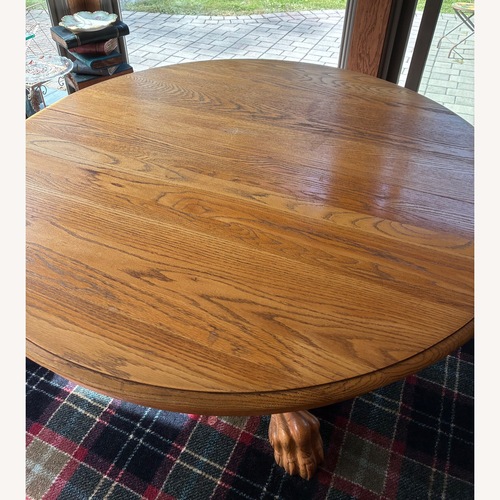 Used Round Oak Table With Carved Base and Six Chairs for sale on AptDeco