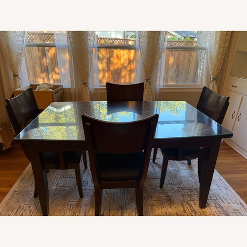 Used Dark Wood Dining Table with Glass Top and 4 Chairs for sale on AptDeco